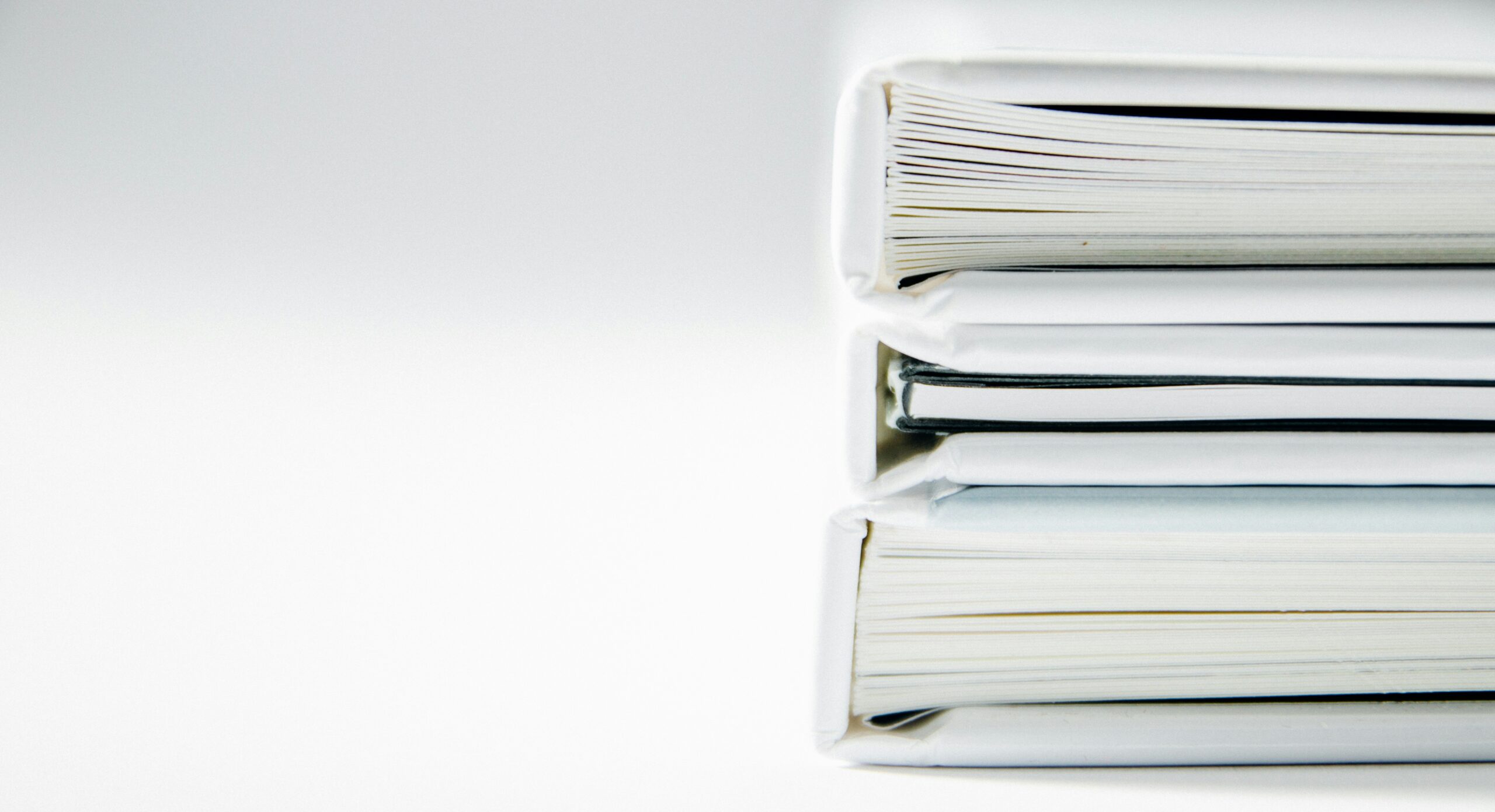 Small business owner overwhelmed by stacks of financial paperwork and receipts needing bookkeeping catch-up